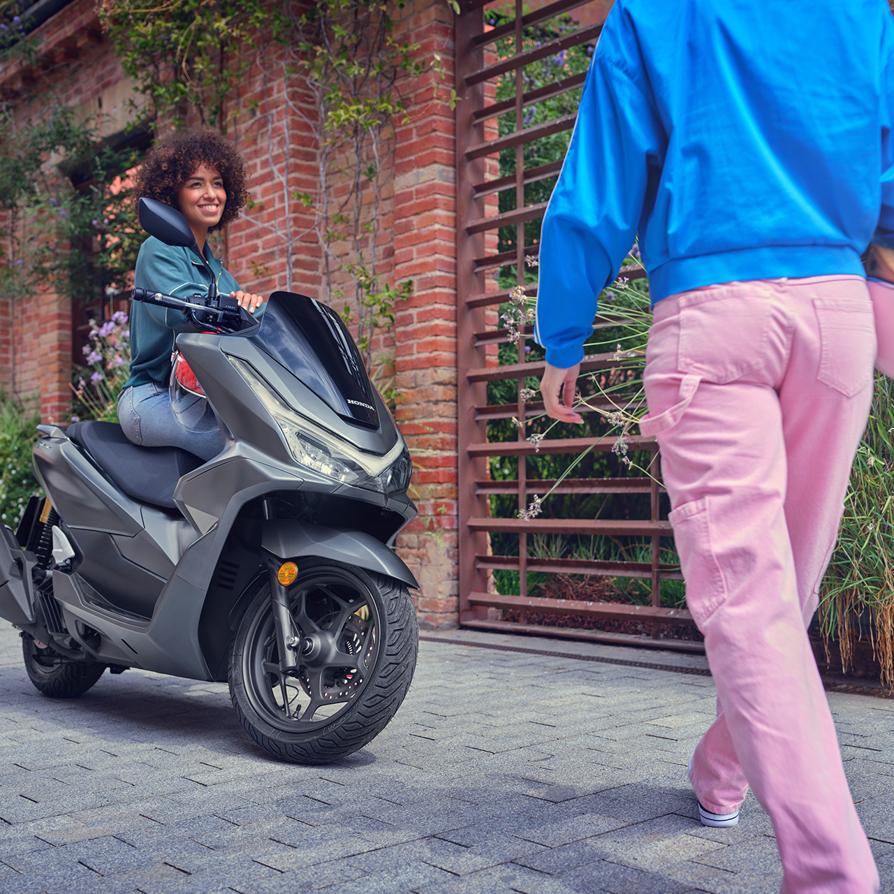 Figurant sa pri stretnutí s priateľom opiera o motorku PCX 125.